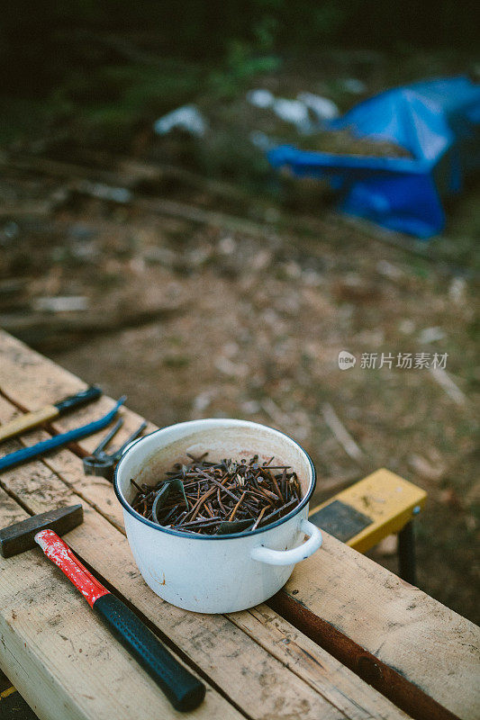 一桶生锈的旧钉子和一些工具