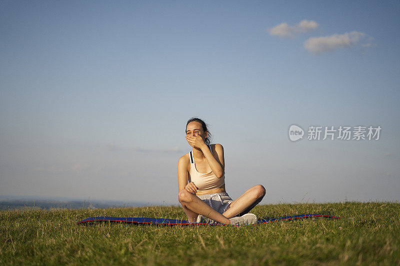 青少年的精神。美丽的少女在大自然的户外训练后休息。