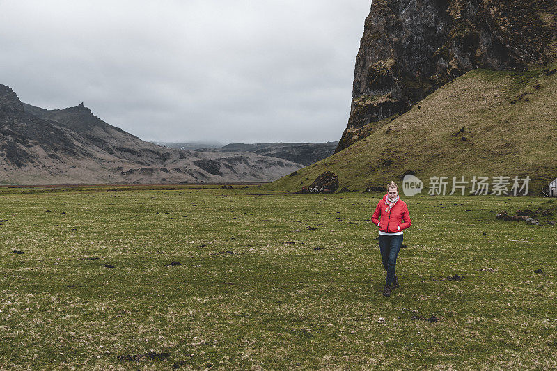 一个穿着红色夹克的女人在冰岛徒步旅行