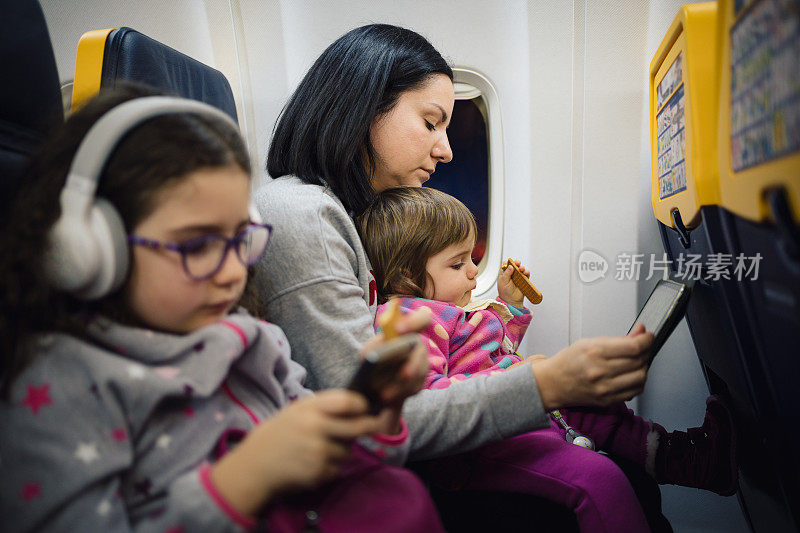 妈妈和她漂亮的女儿们坐飞机旅行。