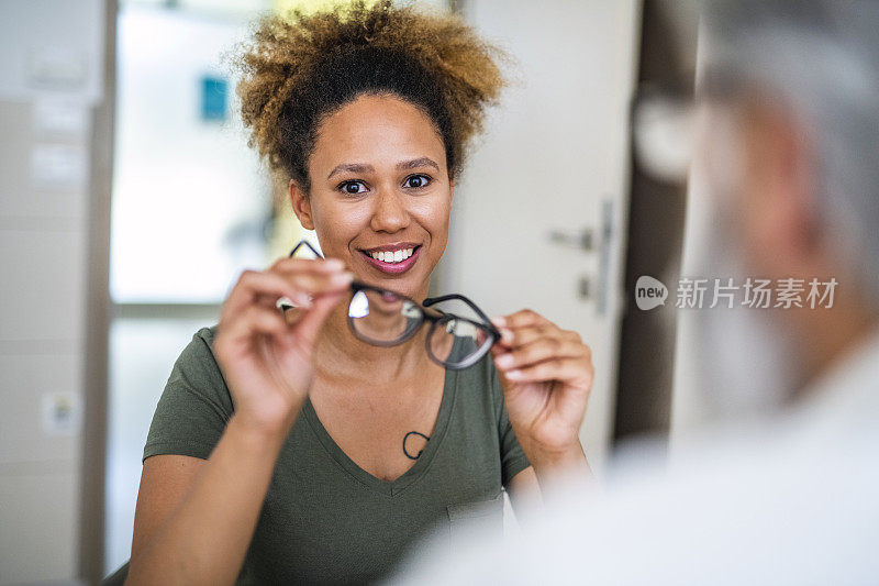 一位女士在眼科诊所测试她的新眼镜