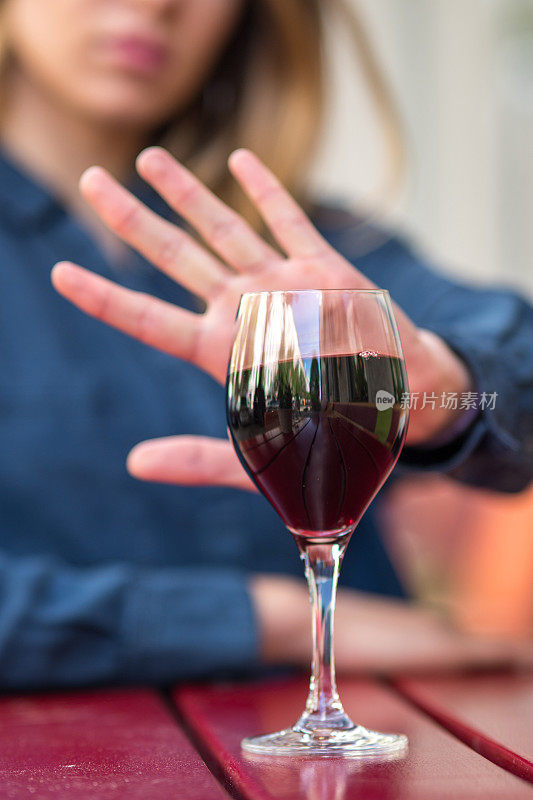 用手势拒绝喝葡萄酒或酒精饮料的女性。