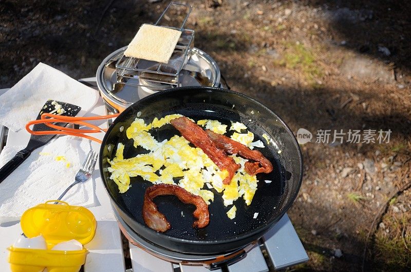 熏肉和鸡蛋放在野营炉上