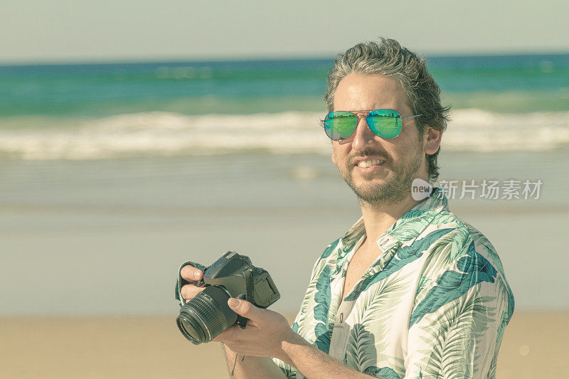 快乐的摄影师在海滩上拍照