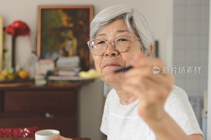 年长的女士用勺子给你提供食物