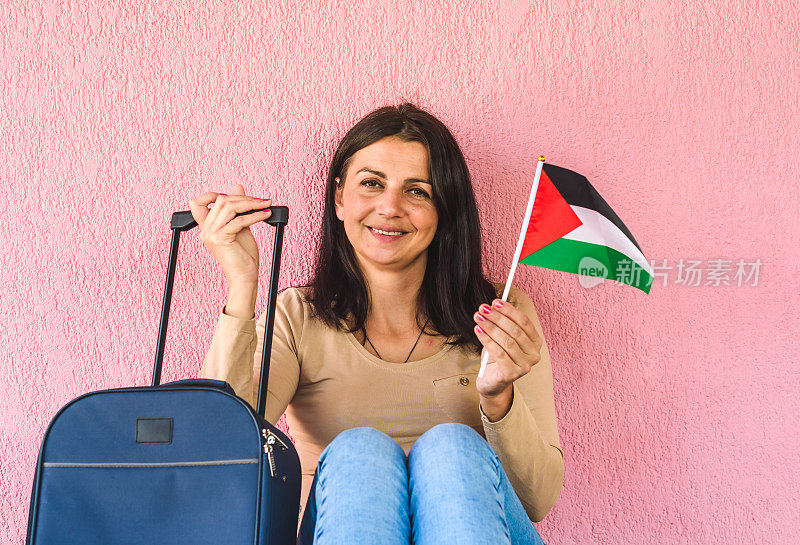 拿着旅行袋和巴勒斯坦国旗的女人