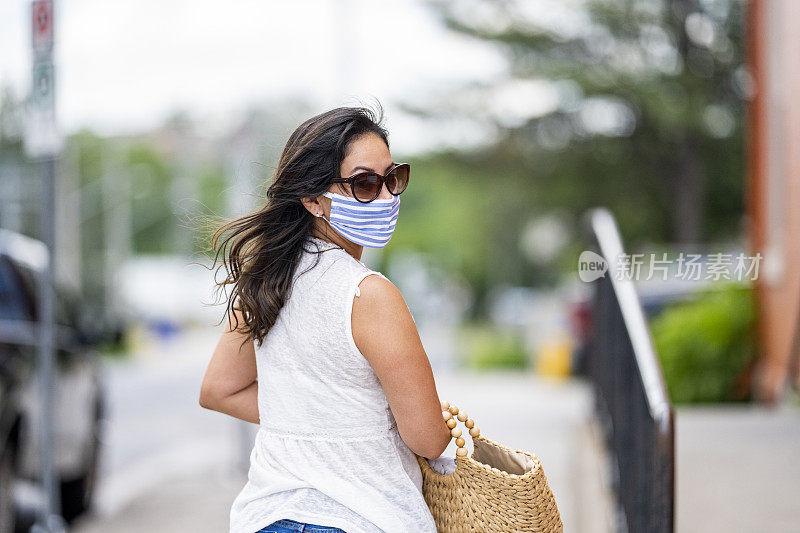 一名西班牙妇女戴着防护面具在市中心购物