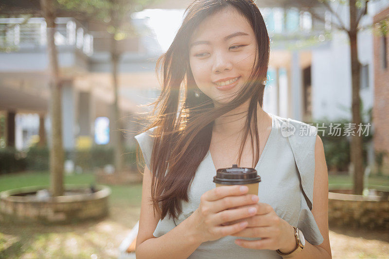 年轻时尚的亚洲女人拿着外卖咖啡