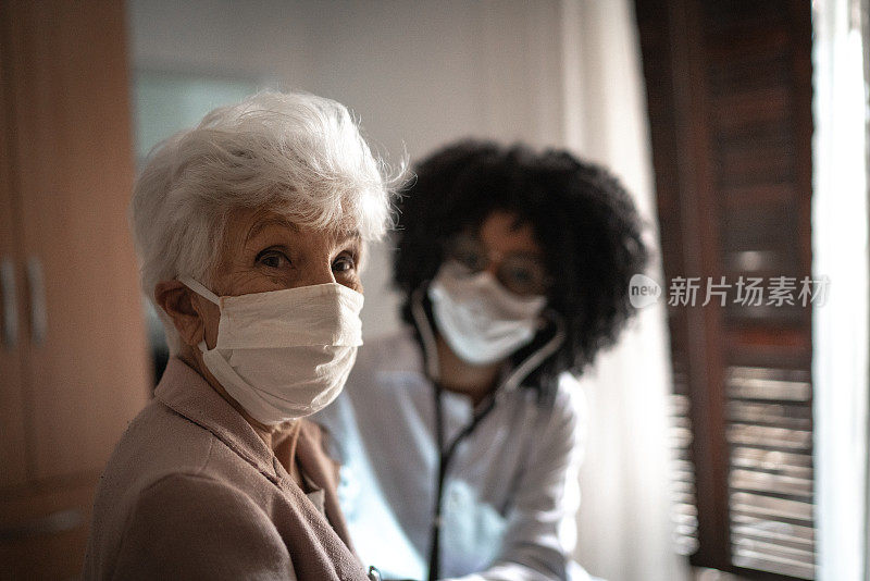 家访期间健康访视员和一位老年妇女的肖像