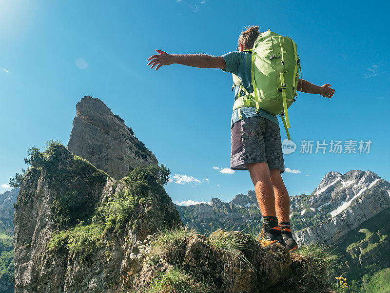 男人在山顶张开双臂