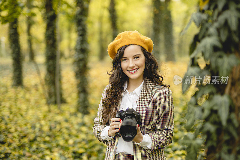 女摄影师正在森林里拍照