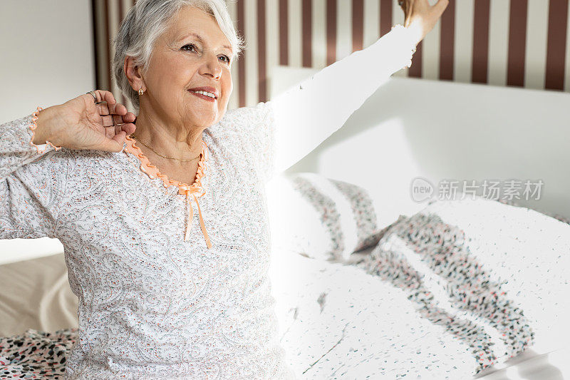 老女人在卧室里，醒来做伸展运动
