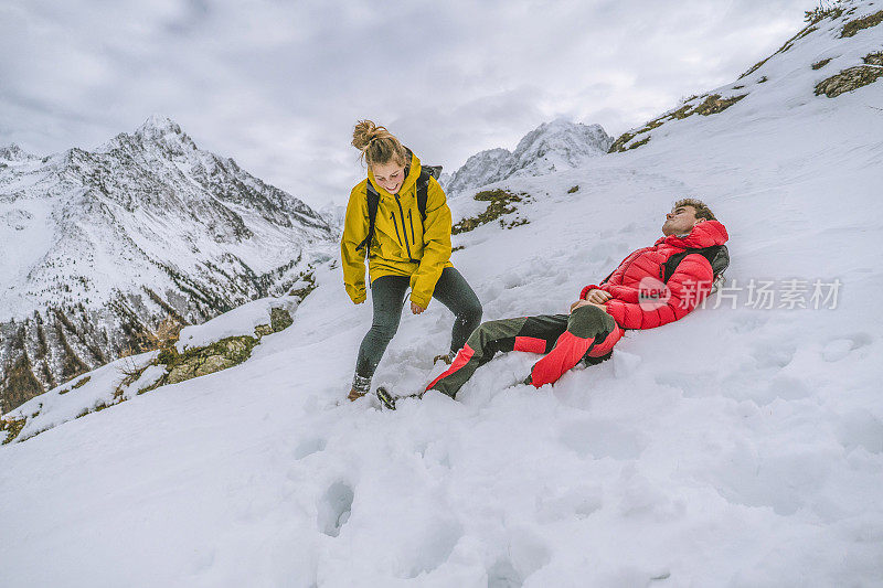 一对年轻的徒步旅行者在白雪皑皑的山脊上嬉戏