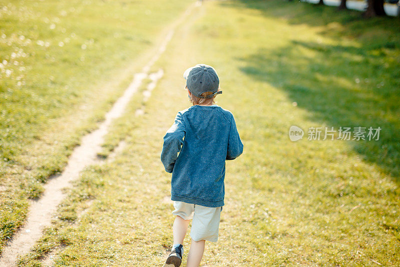 8岁男孩在草地上奔跑，戴着防护面具