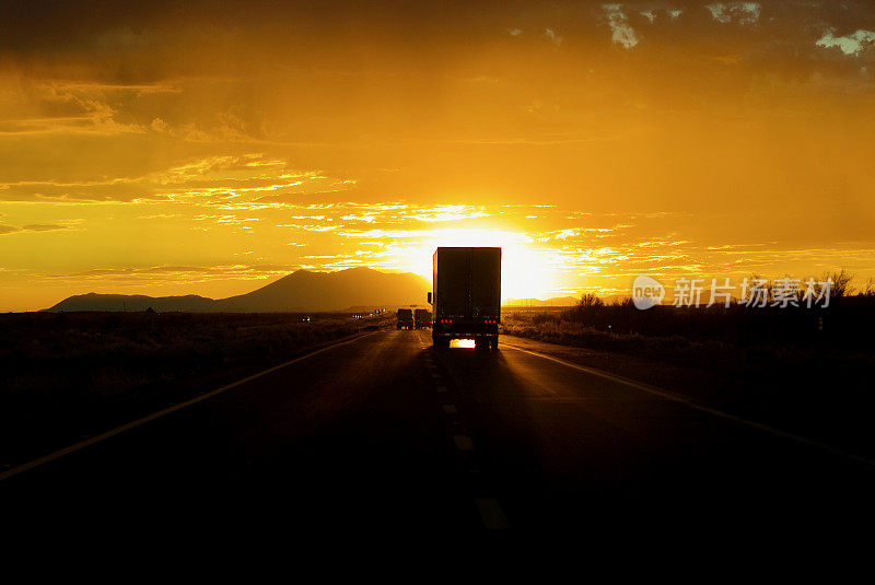 日落公路上的卡车剪影