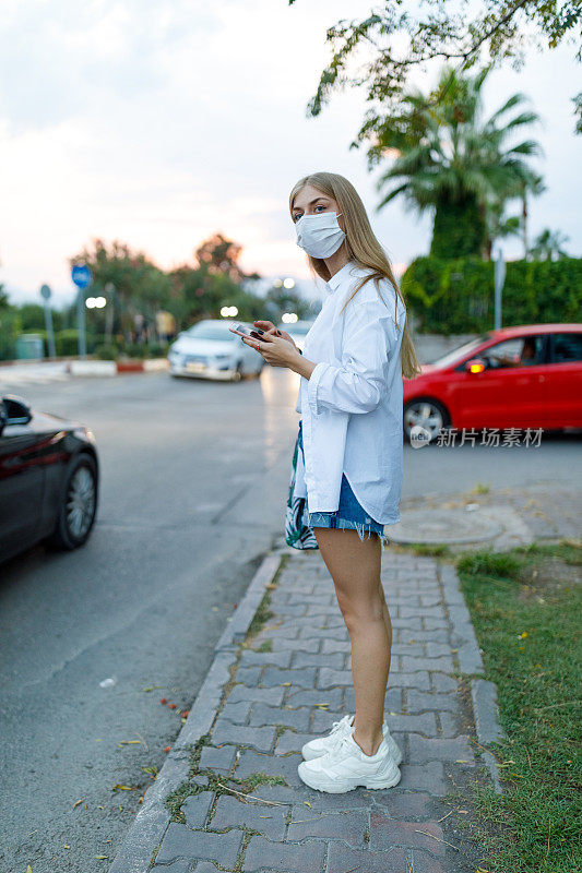 年轻的金发女人在等出租车