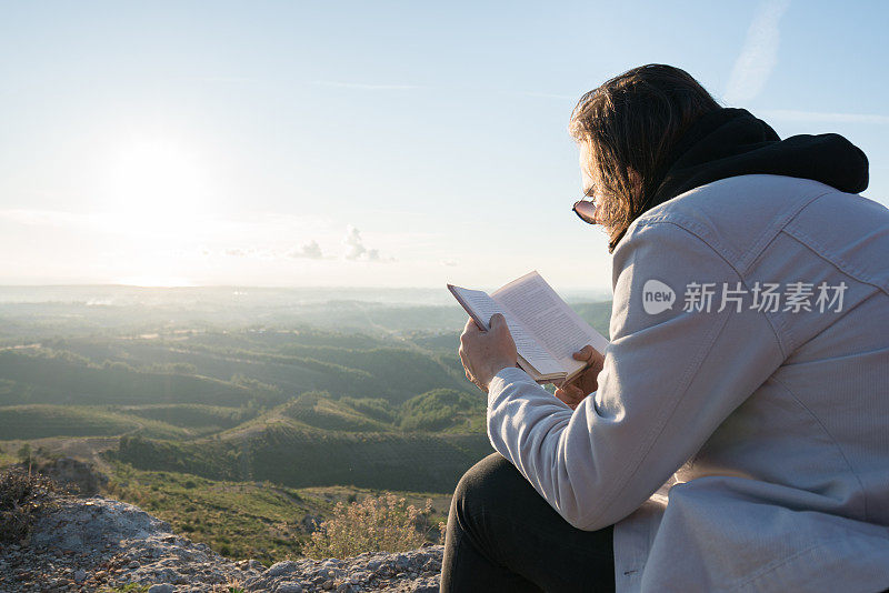 少年旅人在山顶上读书