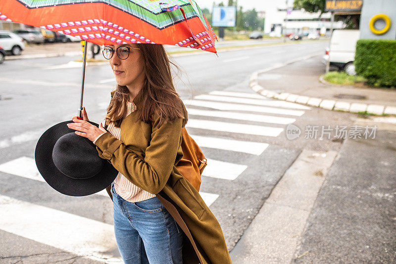 一个年轻女子在雨天等待过马路