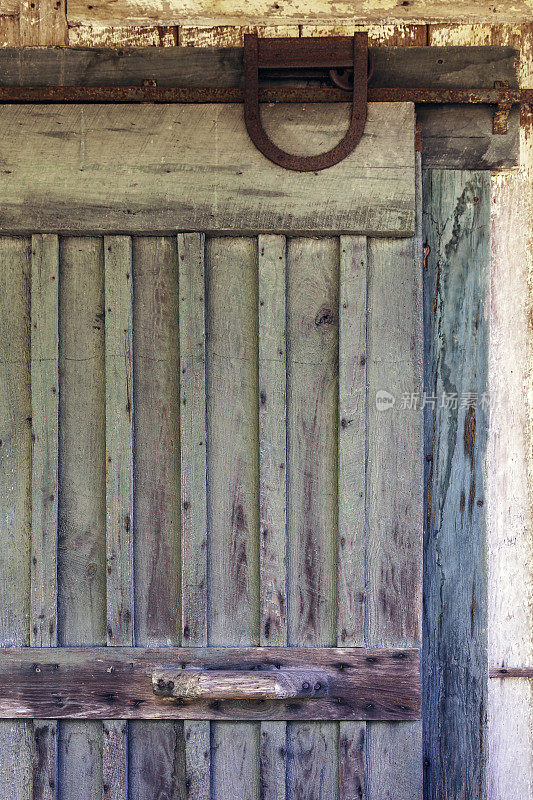 彩色和乡村滑动谷仓门显示古董铰链硬件和手工雕刻木制把手
