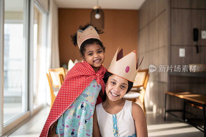 可爱的姐妹们在家里戴着皇冠玩耍