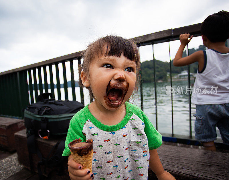 糖冲!兴奋的巧克力冰淇淋脸蛋可爱的年轻女孩