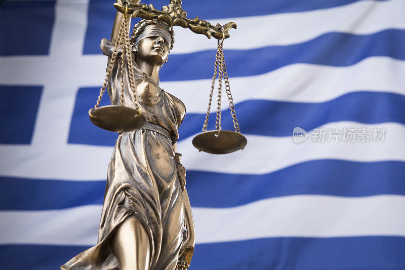 正义的雕像Themis或justtia，被蒙上眼睛的正义女神，面对着希腊国旗，作为一个法律概念