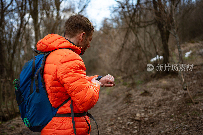 徒步旅行者在探险中查看手表上的时间