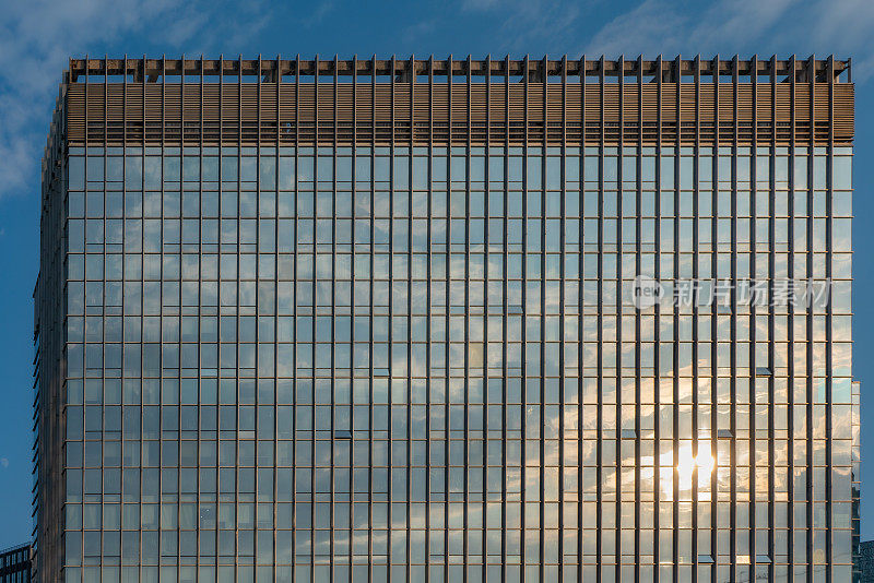 蓝天白云映在现代建筑特殊的玻璃外墙上
