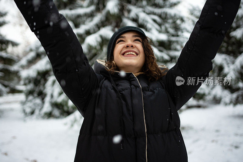 快乐的年轻女子在玩雪