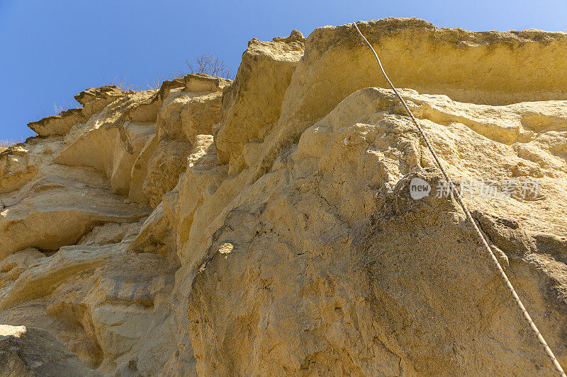 绳索安全系统附着在被侵蚀的悬崖上的岩石上