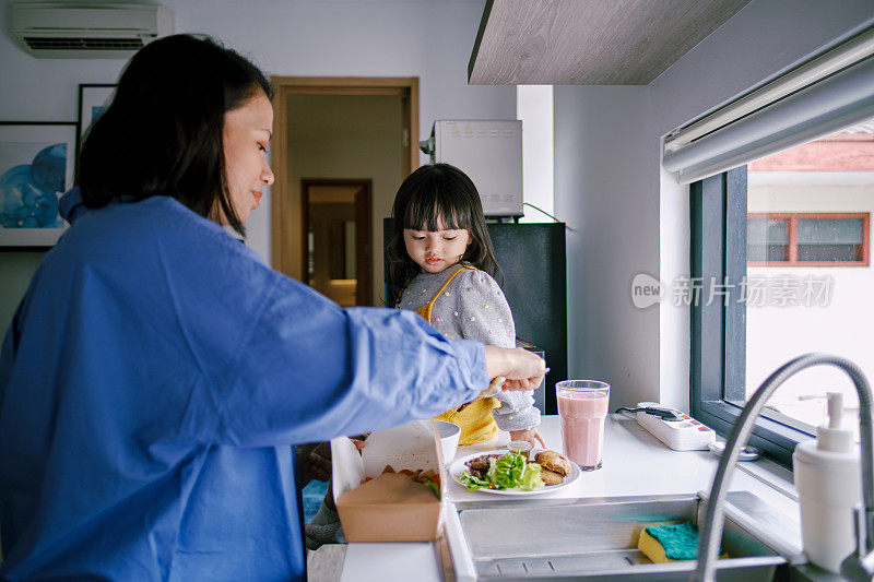 母亲和女儿一起在厨房里准备早餐