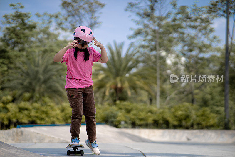 亚洲中国女孩在滑板公园享受滑板的乐趣