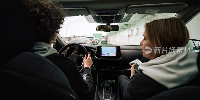 人在室内开车，男人开着车，美女靠近。旅游摄影、旅行、度假摄影的概念。