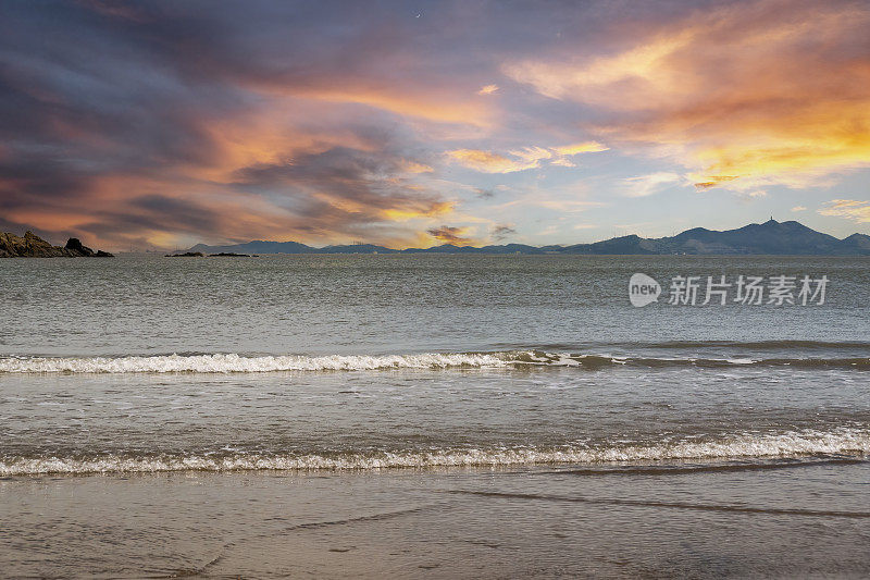 夕阳下的海浪拍打着海滩