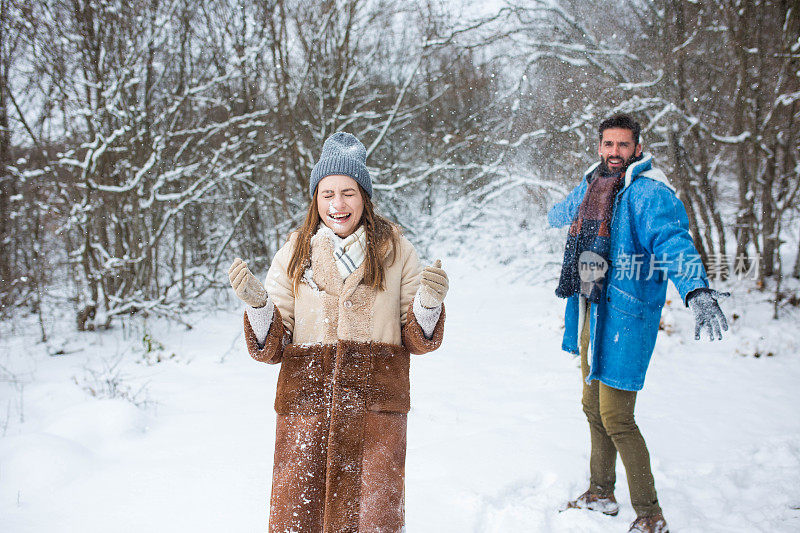 一对夫妇在寒冷的冬天享受初雪