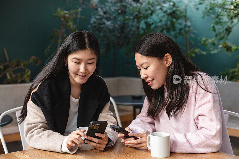 女性朋友在咖啡馆边喝咖啡边看智能手机上的任何内容
