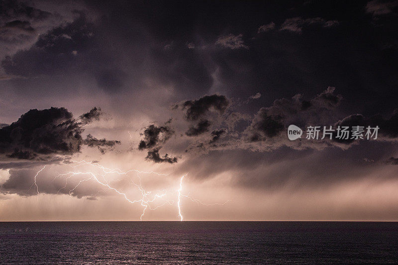 海洋上空的极端风暴伴随着降雨，闪电和黑暗的天空，云层