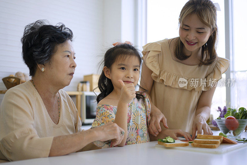 奶奶、妈妈和孙女在厨房准备食物。