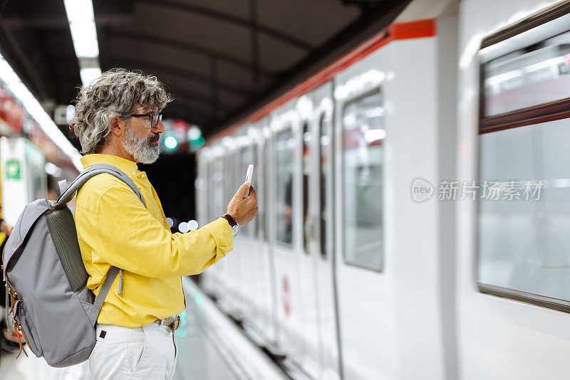 老人在地铁里使用智能手机