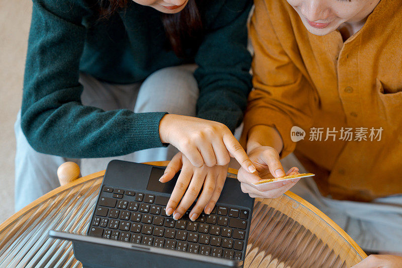 年轻的亚洲夫妇拿着平板电脑，在家接收包裹，享受送货上门服务。网上购物，移动支付。愉快的购物体验