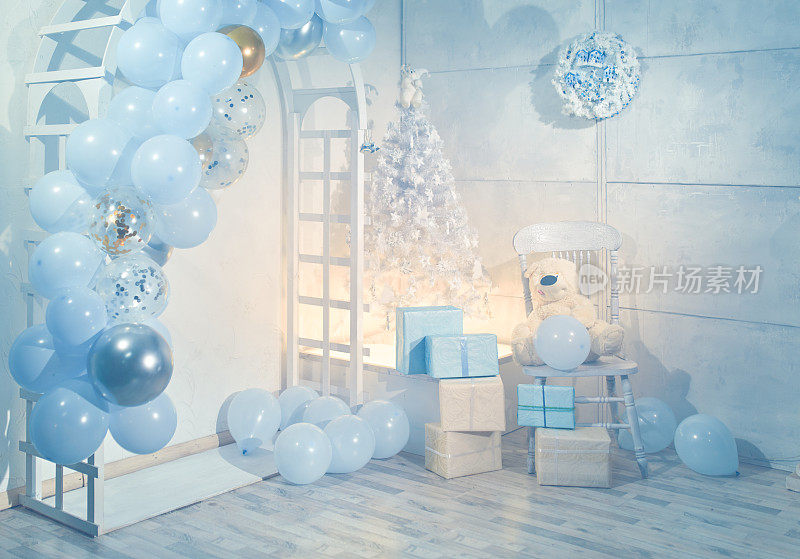 白色的木制拱门上装饰着蓝色的气球，这是圣诞节的装饰