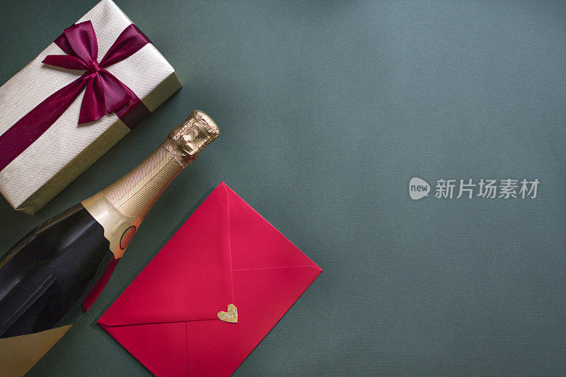 情人节卡片，顶部视图香槟瓶，礼盒和绿色背景的情书