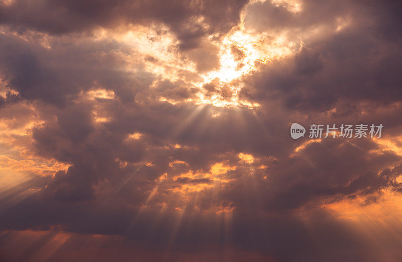 戏剧性的日落天空背景:阳光穿透黑色雷云