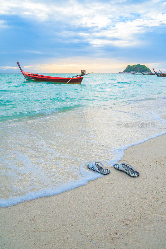 人字拖(凉鞋)在沙滩上。暑假的概念