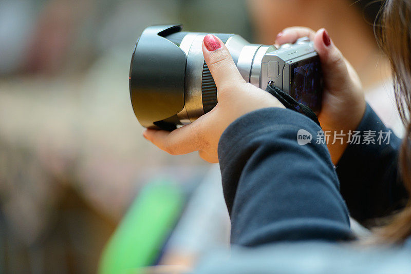 年轻亚洲女子的手拿着相机拍照