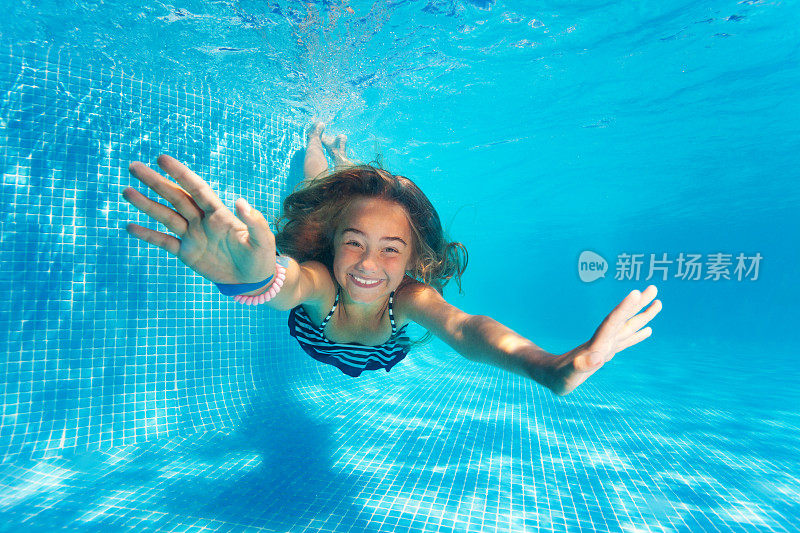肖像的十岁前女孩跳水与乐趣在游泳池
