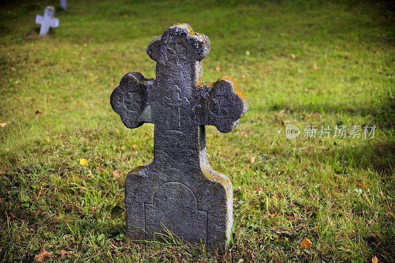 古老的，石头，墓碑十字架在绿色草地的背景。