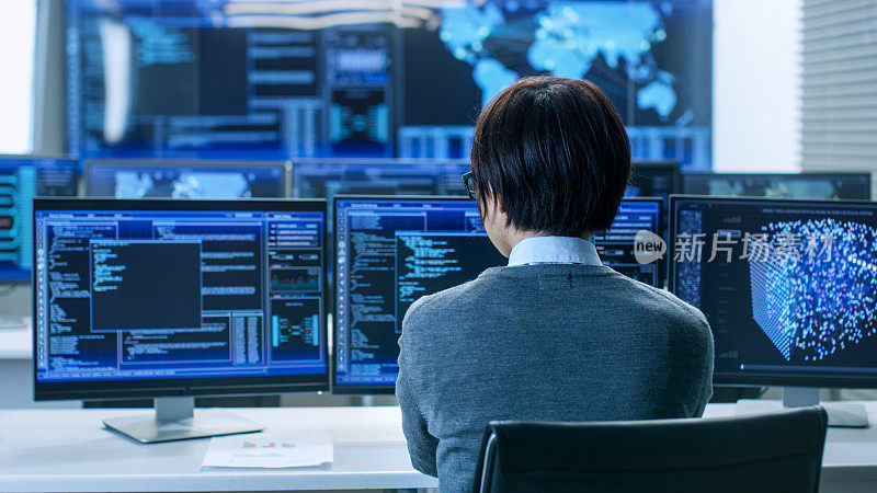 在系统控制室，技术操作员在他的工作站使用多个显示图形的显示器工作。从事人工智能，大数据挖掘，神经网络项目。
