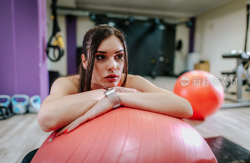 健身女孩在健身房用健身球健身