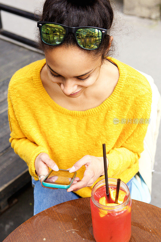 年轻女子坐在咖啡馆里玩手机